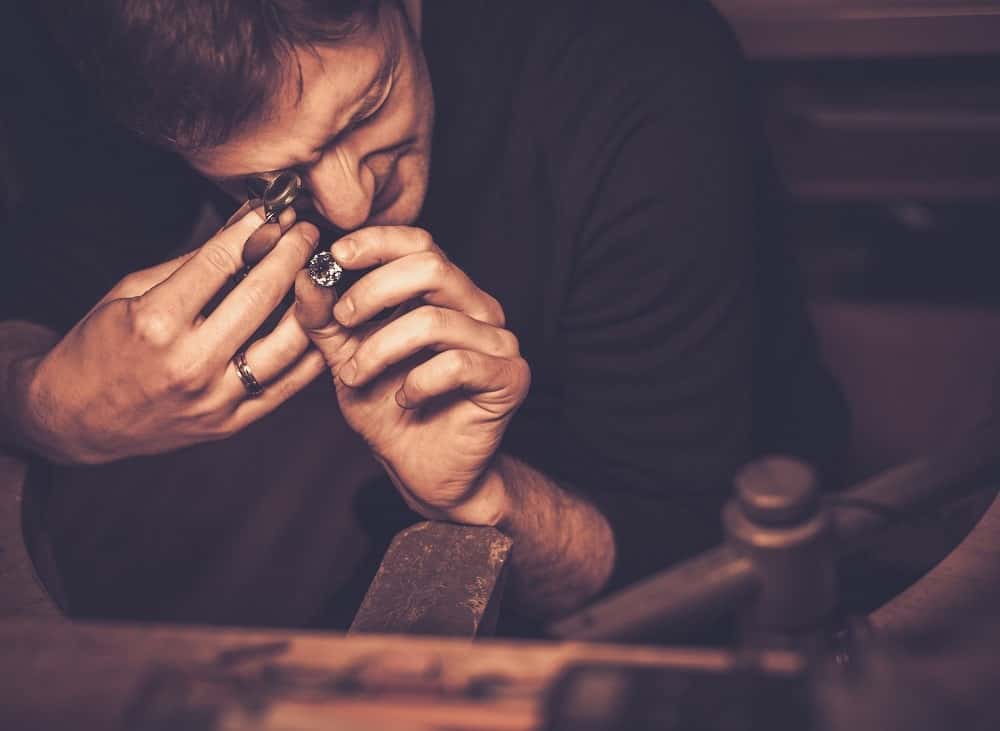 Jeweler evaluating gold jewellery to determine how much it is worth